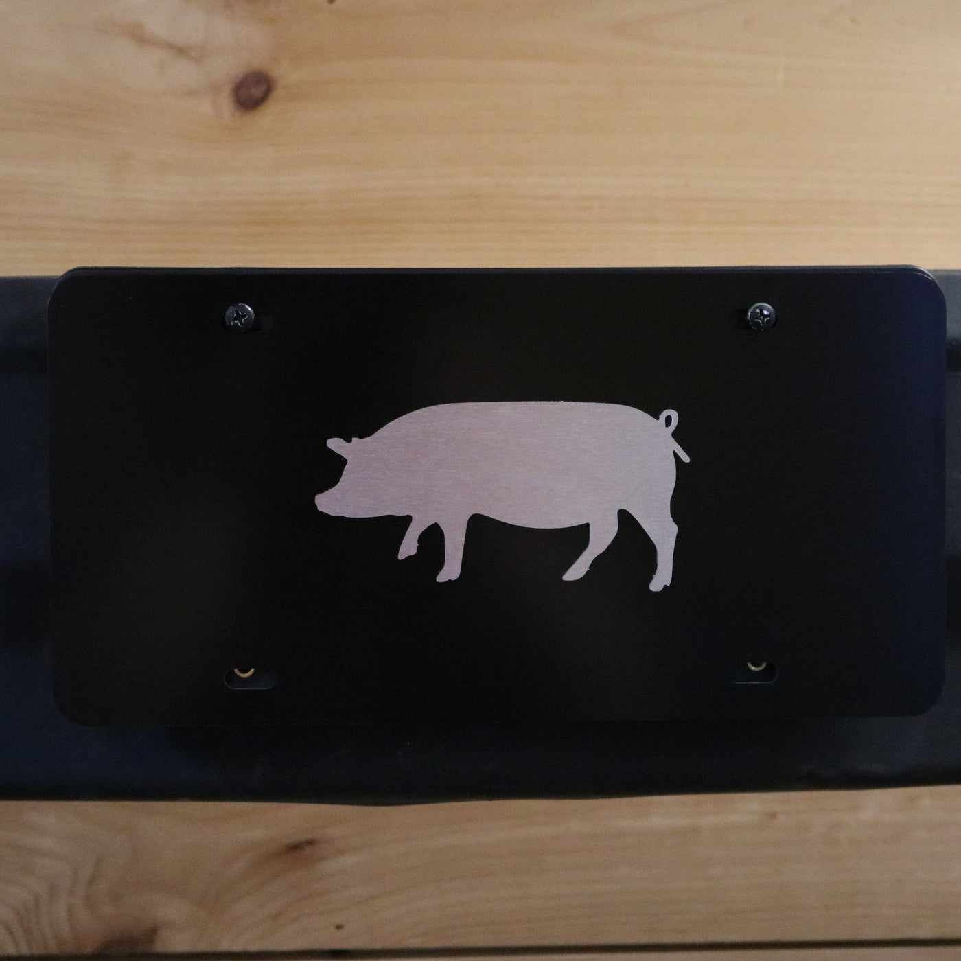 Tag in black with 3-D pig in brushed finish.
